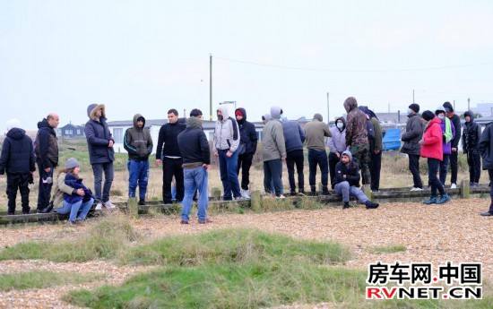2021年11月24日,移民在抵达英国邓杰内斯角海岸后等待。新华社发(史蒂夫·芬恩摄)